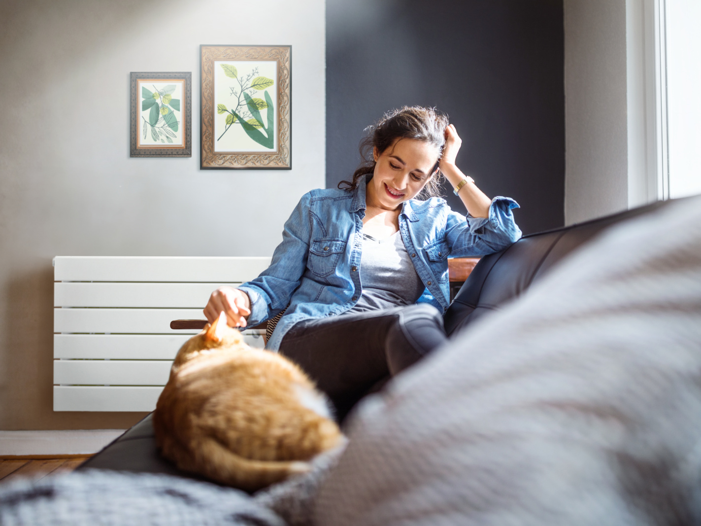 Zehnder_RAD_NovaNEO_Relax-HG.tif Beautiful young woman relaxing on sofa with her cat in living room.